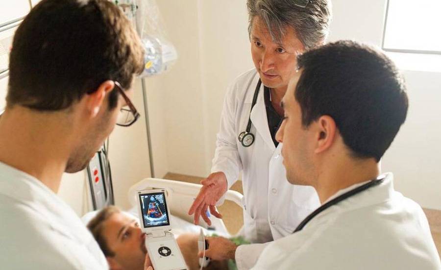A group of doctors train on a new device.