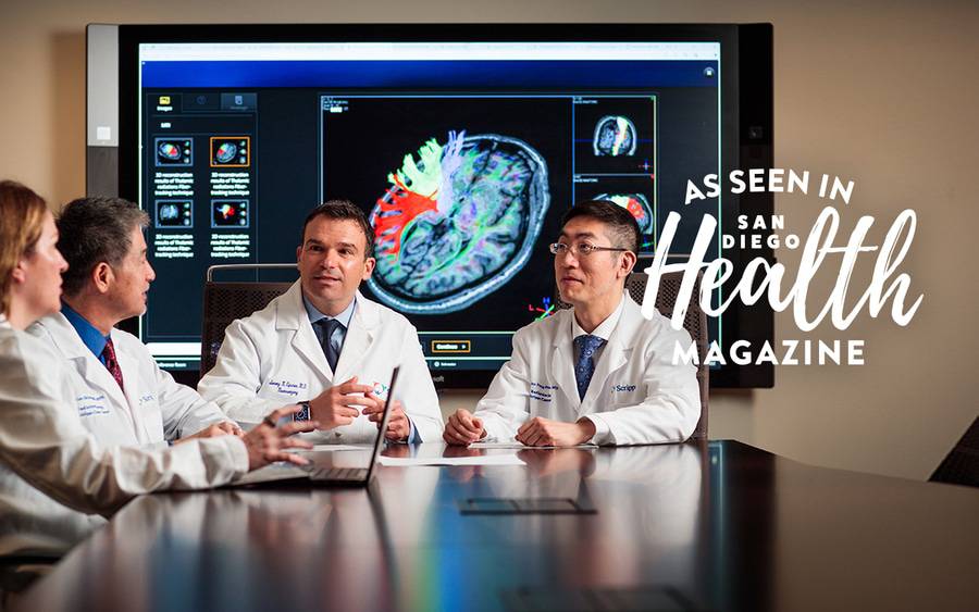 Scripps neuro-oncology team members sit at a table as they collaborate on treatment options. San Diego Health Magazine