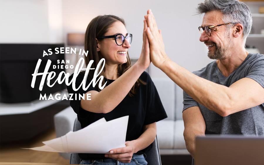 A man and a woman high five after making a charitable donation.