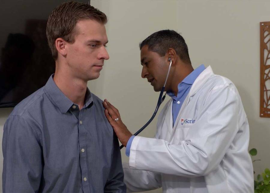 Samir Makani, MD, a specialist in interventional pulmonology at Scripps Memorial Hospital Encinitas checks Rob Church's breathing with a stethoscope.