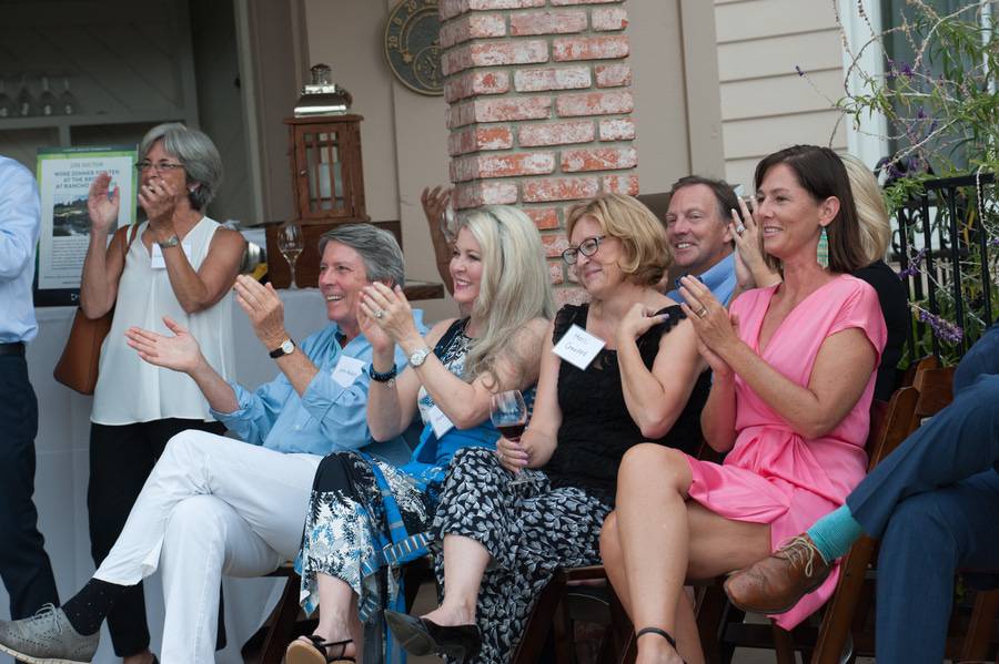 A group of Scripps donors clap and smile at an exclusive Scripps opportunity event.