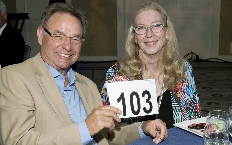 Fred and Lynda Allen hold number card 103 at a charity auction.