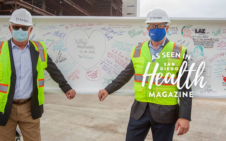 Tony Cortes and Dan Yates, board members of The Conrad Prebys Foundation, stand in front of a signed
support beam.
