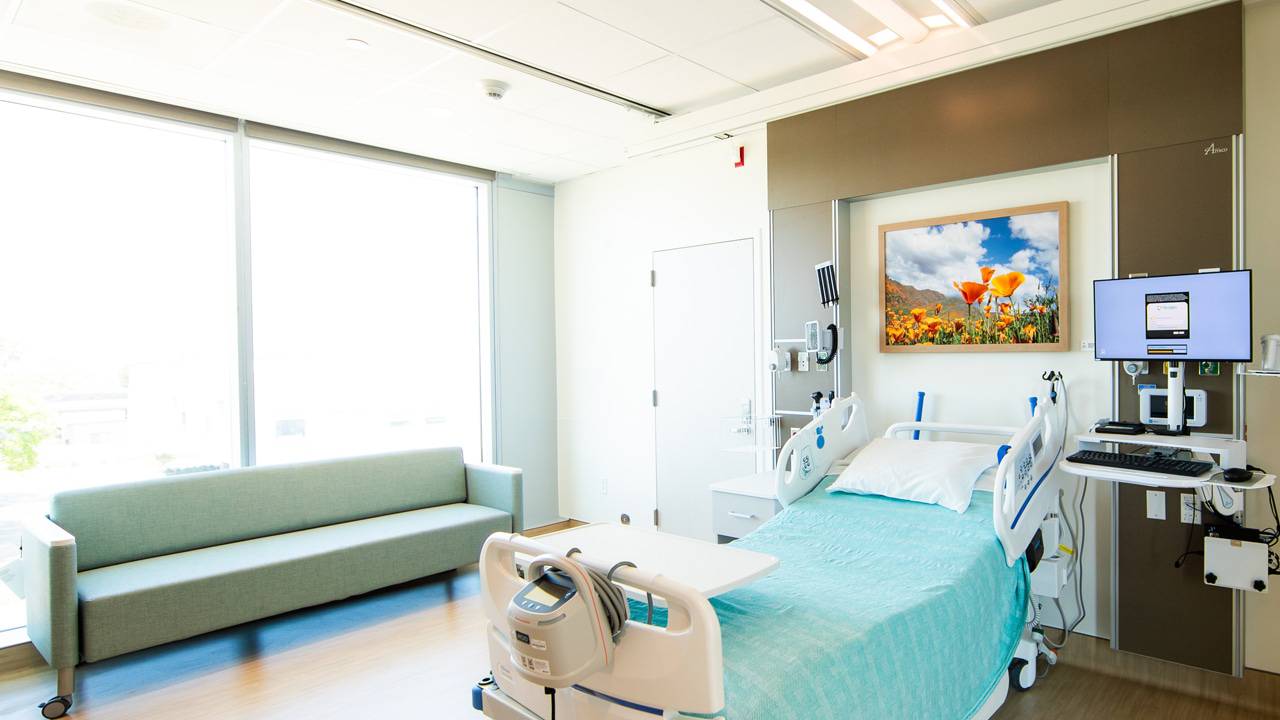 A framed artwork with orange California poppies is an example of the Healing Artwork in a patient room at Lusardi Tower at Scripps Memorial Hospital Encinitas.