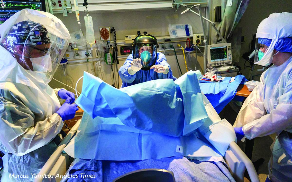 Scripps physicians in full personal protective equipment working in a COVID-19 room.