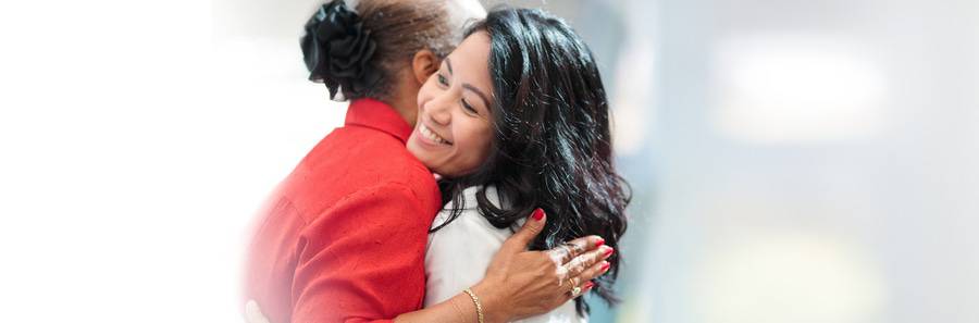 A Scripps patient hugs her caregiver after successful treatment.