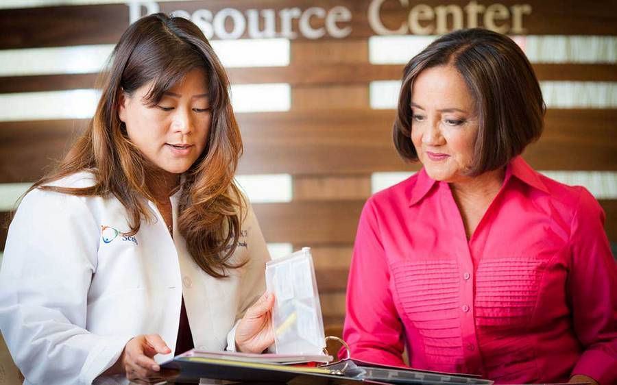 A nurse navigator talks to a woman about her cancer treatment.