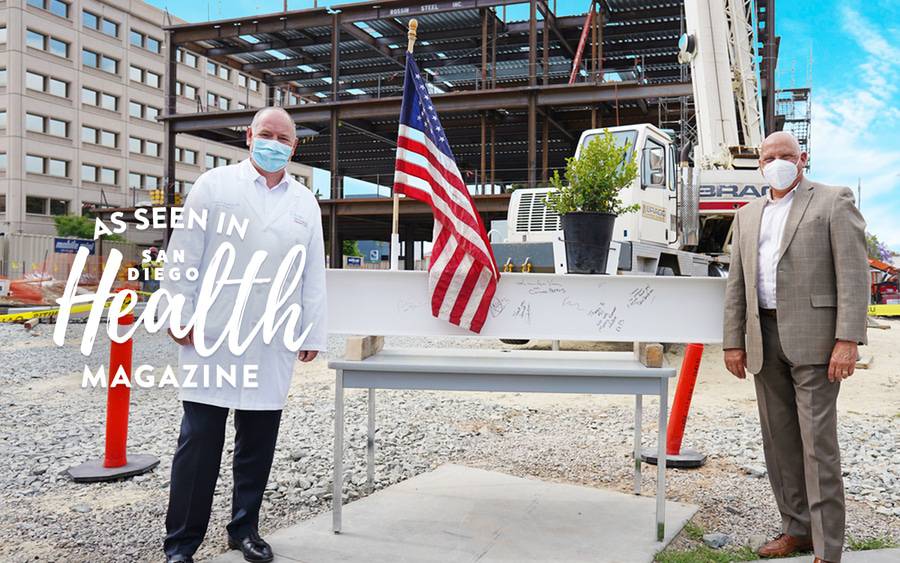 Thomas Buccholz, MD, and John Engle stand near the forthcoming cancer center in San Diego at the topping-off ceremony.