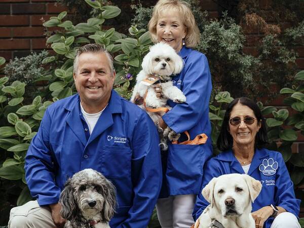 A group of people holding therapy dogs