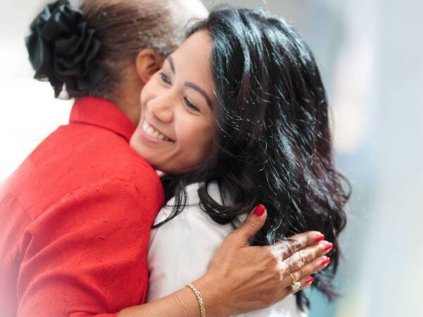 A Scripps physician smiles as she hugs her patient who thanked her for her service.