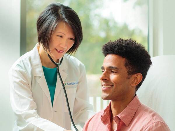 Scripps physician Siu Ming Geary, MD, stands confidently inside a Scripps Health facility.